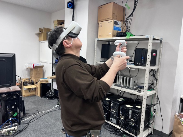 VRゴーグルをつけ、カメラワークや構図を決定するライブパート演出担当の錦織